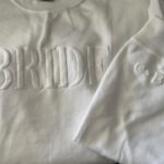 Custom Bride Embossed Puff Print Sweatshirt in white folded nicely.
