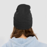 Back profile of a woman wearing a black classic custom cuffed beanie.