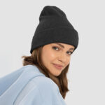 Side profile of a woman wearing a black classic custom cuffed beanie.