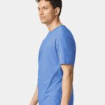 Man standing sideways wearing a heather royal Gildan softstyle short sleeve t-shirt.