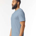 Man with beard standing sideways wearing a stone blue Gildan softstyle short sleeve t-shirt.