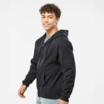Man standing sideways wearing custom all over zip-up hoodie black showing off sleeves